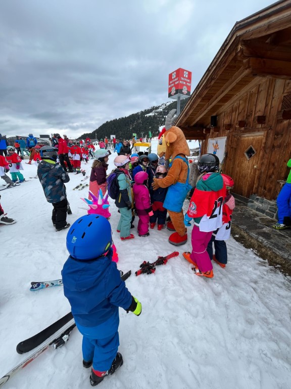 Kinder beim Skikurs mit Maskottchen Pitzi am Hochzeiger